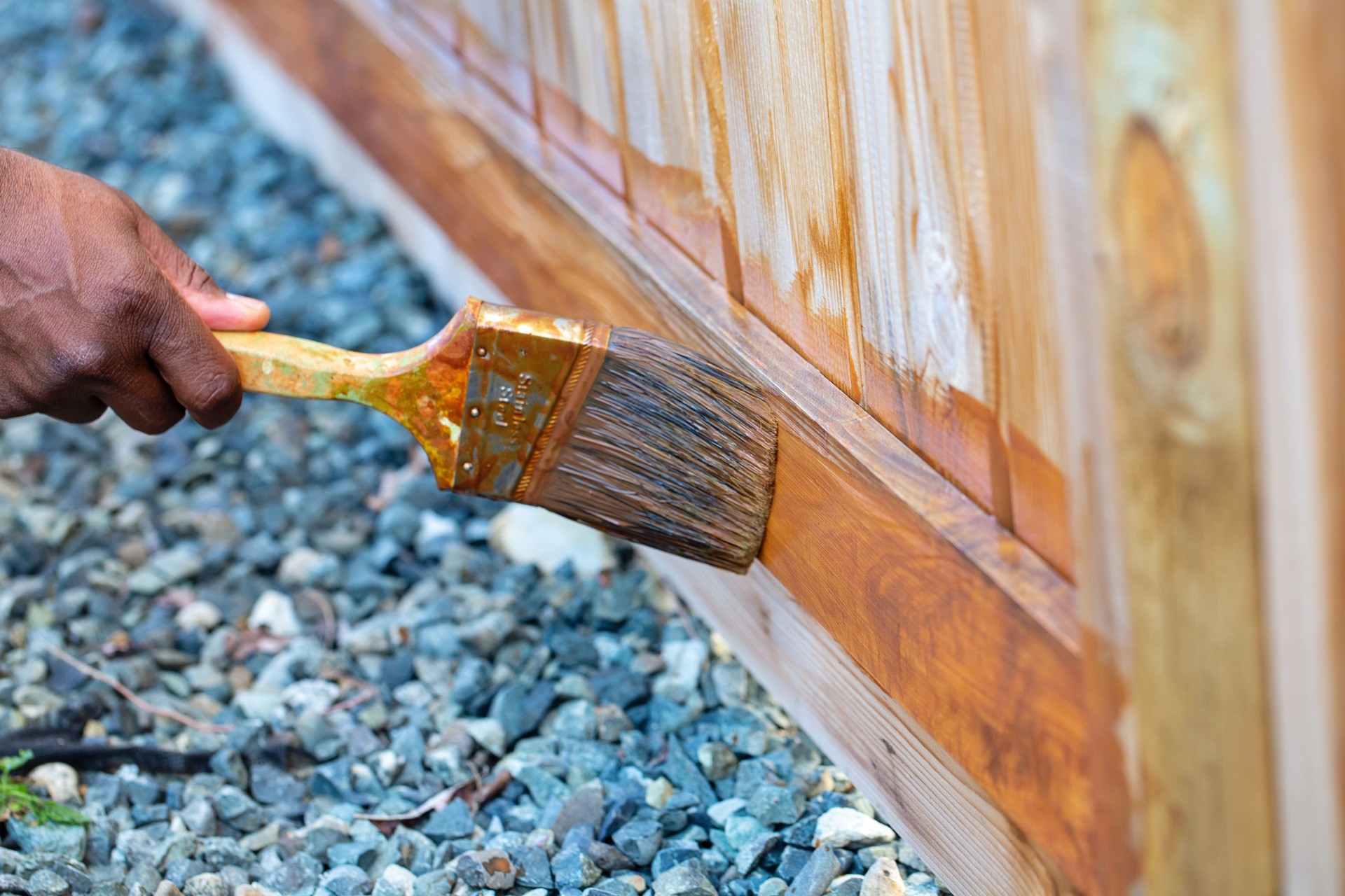 Brown-skinned Hand Applying Wood Stain